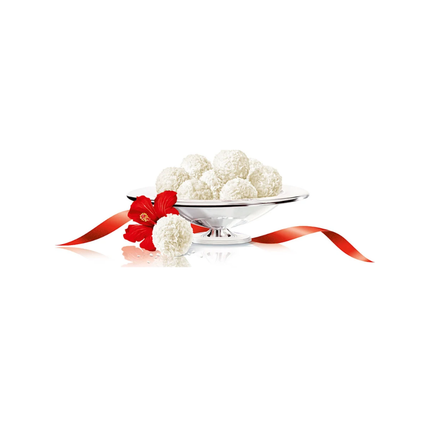 Kokos-Mandel Pralinen (Raffello) in Schale mit rotem Blütenakzent