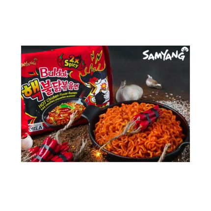 Buldak 2x Spicy ramen noodles in a black pan with red spicy packet
