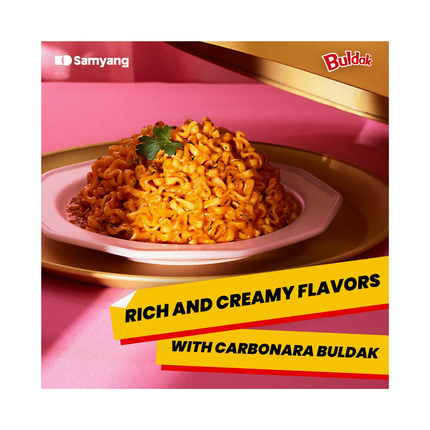 Bowl of creamy orange Buldak Carbonara noodles on a pink label card