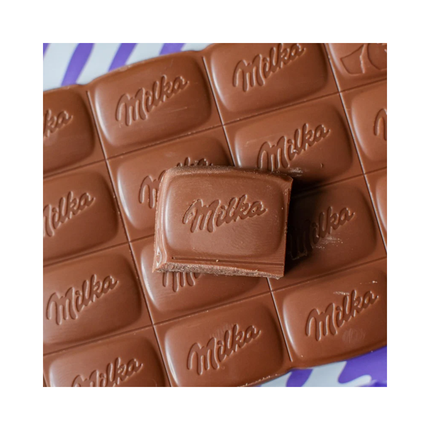 Nahaufnahme: Milka Alpenmilch-Schokolade Riegel mit geprägtem Milka-Schriftzug