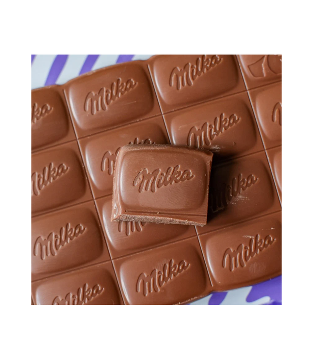 Nahaufnahme: Milka Alpenmilch-Schokolade Riegel mit geprägtem Milka-Schriftzug